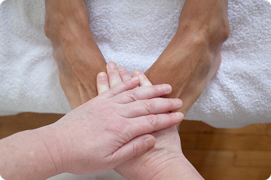 réflexologie plantaire mains sur les pieds